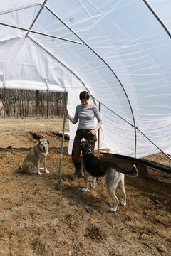Flower Farmer in greenhouse playing with her dogs