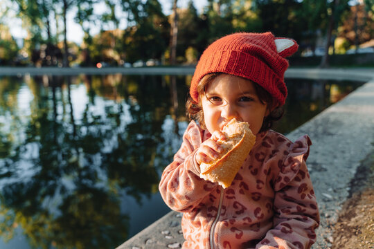 Little girl eating bread outside