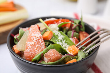 Delicious salad with pomelo, tomatoes and cheese in bowl, closeup
