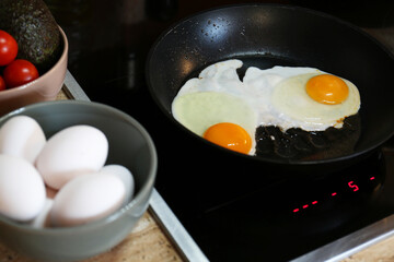 Frying eggs in kitchen for tasty breakfast