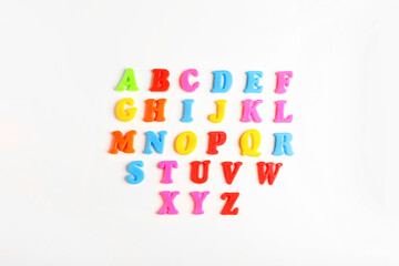 Colorful magnetic letters on white background, flat lay. Alphabetical order