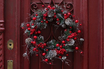Beautiful Christmas wreath hanging on red door © New Africa