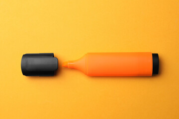 Bright orange marker on orange background, flat lay