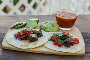 Delicious tacos and ingredients on wooden table. Mexican food