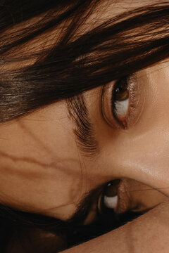 Close Up woman's portrait with brown eyes in sun light