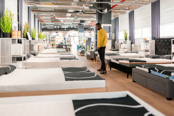 Man Looking At Mattress In The Shop