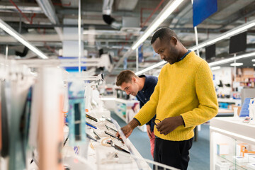 Clients Watching Phones In Electronics Store