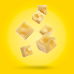 Pieces of delicious cheese falling on yellow background