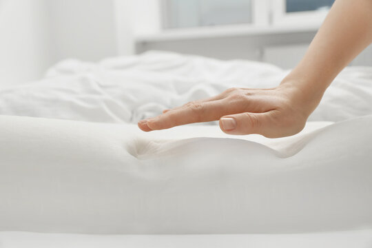 Woman with orthopedic memory foam pillow on bed, closeup. Space for text