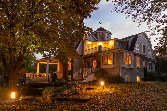 Front of Craftsman house with porch in Autumn at sunset with foliage