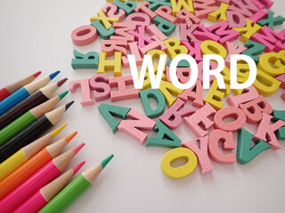 カラフルな色鉛筆とアルファベットの上に、wordワードの単語