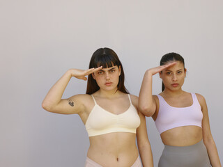 Two woman in underwear giving military salute