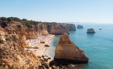 Paradise cliff beach with people enjoying summer day