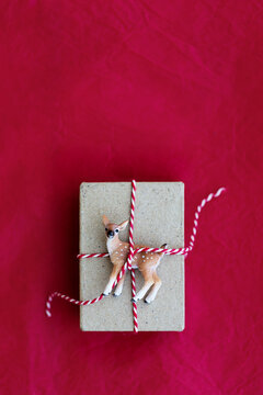 Christmas gift wrapped with deer ornament and red and white stri