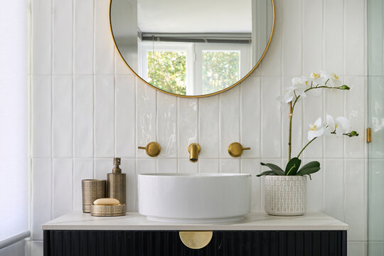 Bathroom with circular hand basin and brass tap ware