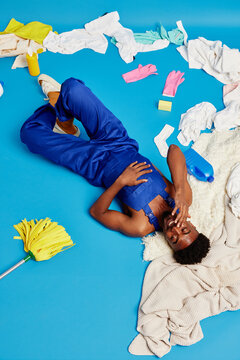 Tired black man resting near dirty clothes