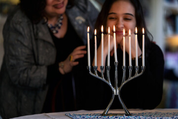 Hanukkah: Girl And Mother Admire Lit Candles