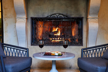 Close-up of wine and cheese plate in front of fireplace
