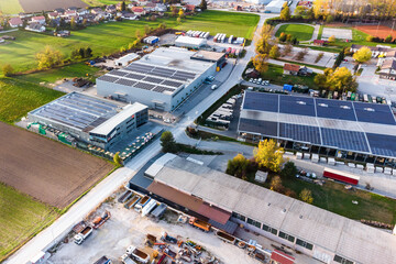 Industry with low carbon footprint. Industrial warehouses with solar panels on the roof. Aerial...