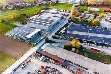 Industry with low carbon footprint. Industrial warehouses with solar panels on the roof. Aerial view	