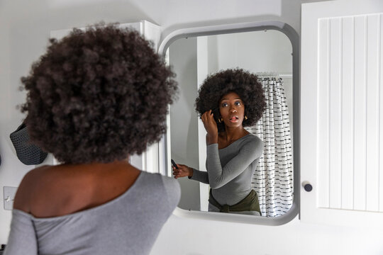 Black Lifestyle Girl bathroom  applying mascara makeup eye