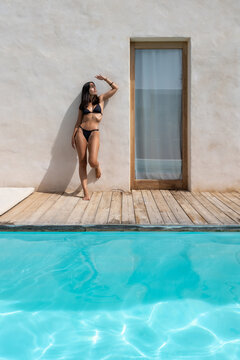 Woman Walking By Pool At Luxury house