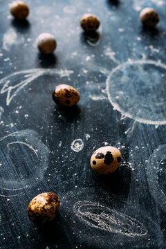 Quail eggs on a coated blackboard with drawings. 