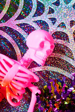 Pink skeleton Halloween decoration on holographic spiderweb