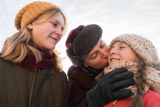 Father kisses his daughter in winter