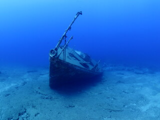 wreck underwater in blue water scuba divers to explore metal on ocean