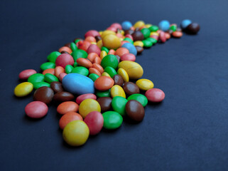 Colorful milk candies for little kids on black background
