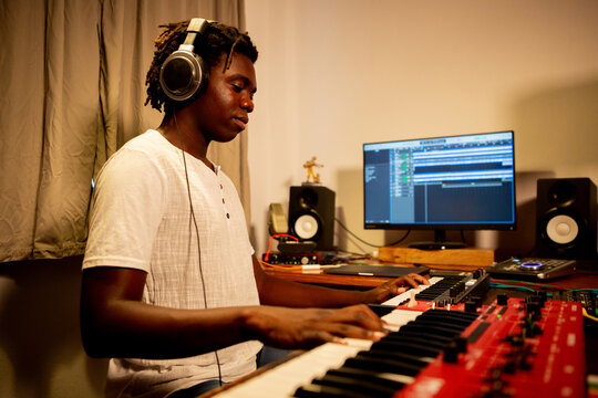Young man enjoys playing music in his studio