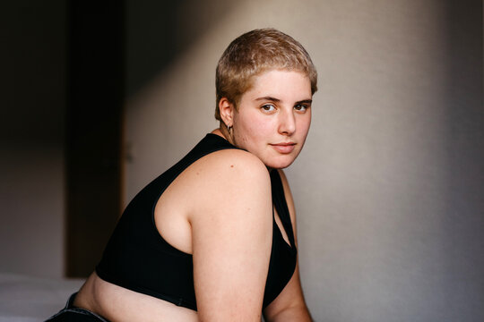 Attractive young non binary person with binder looking at camera