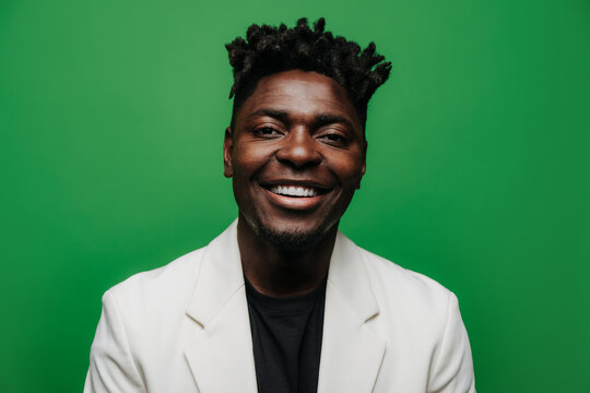 Portrait Of Cheerful Black Man In White Jacket Looking At Camera