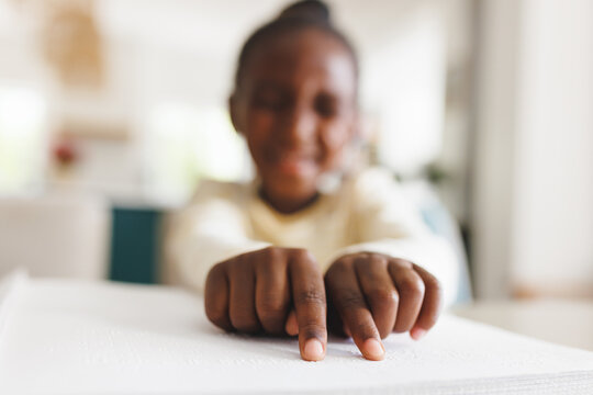 Blind african american girl reading braille