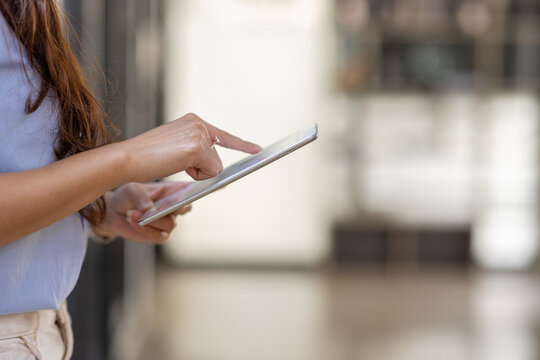 Young Business Asian Woman Using Tablet Ipad, Standing Near The Window In Workplace