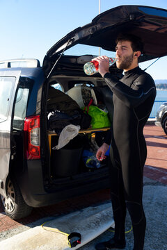 Young man drinking before surfing