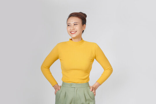 Happy young woman in a turtleneck shirt and shorts is posing