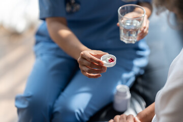 Asian female doctor talking prescribing pills to old senior elderly patient.