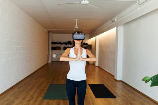 Woman practicing yoga with virtual reality glasses