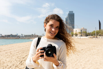 Naklejka premium Young travel photographer by the beach