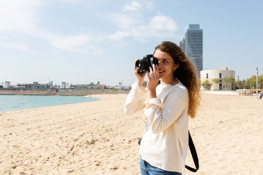 Female tourist taking pics by the beach