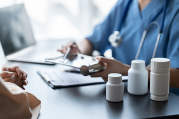 Doctor prescribing medicine giving pills to senior grandmother patient at hospital.