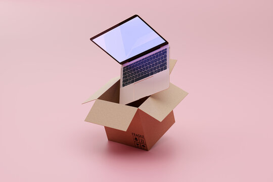 Delivery and shipping goods concept - laptop coming out of box