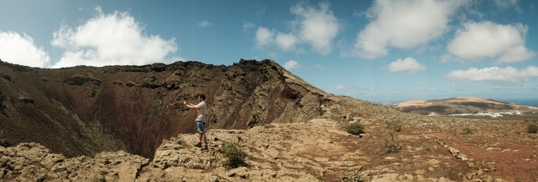 Hiker taking a photo with phone in a volcano