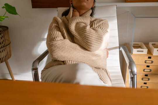 Relaxed woman in neutral winter outfit at cozy office