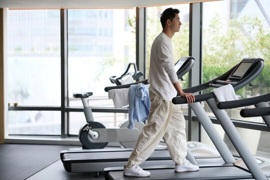 One Handsome Asian Young Man Walking On Treadmill In Gym