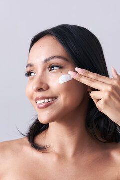 Latina Woman Applies Thick White Sunscreen or Moisturizer to face