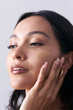 Beauty Image of Latina Woman with Cosmetic Foundation Swab on Face