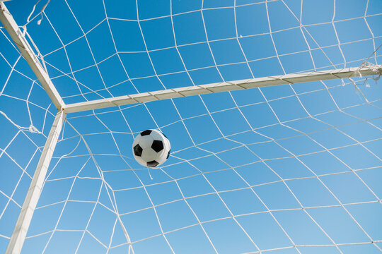 soccer ball in the net on the blue sky background